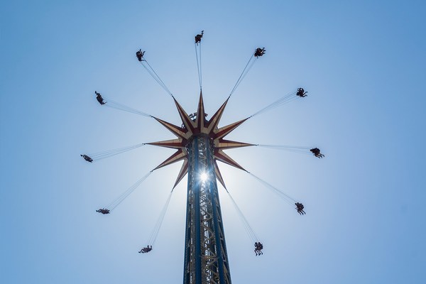 Sillas voladoras de Tornado girando contra el cielo azul