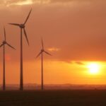 Wind turbines silhouetted against an orange sunset sky, from the Ecotricity website