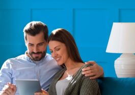 Coppia sul divano che controlla le offerte luce e gas su un tablet