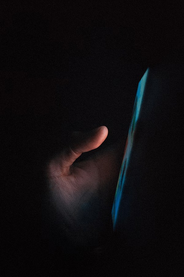 Hand holding a smartphone against a dark background, from Superloop mobile