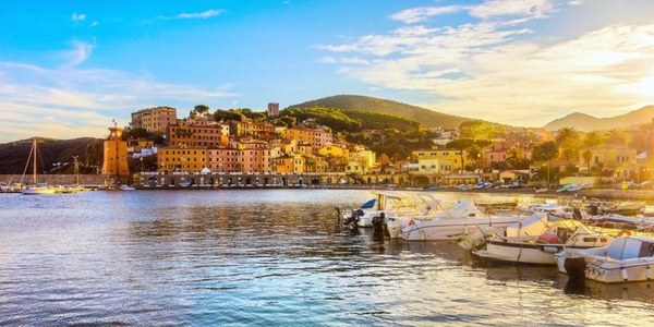 Porticciolo con barche e case colorate sull'Isola d'Elba al tramonto