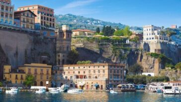 Porto di Sorrento con la scogliera e gli edifici che si affacciano sul mare, immagine di Ferryhopper
