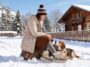 Woman in FitVille SnowVeil winter boots crouching with her dog in the snow outside a cabin