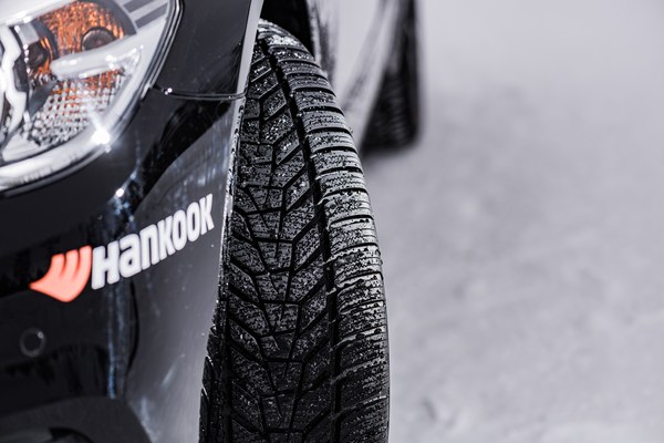 Nahaufnahme eines Winterreifens mit Lamellenprofil am Auto