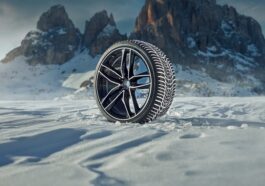 Winter-Komplettrad mit Alufelge im Schnee vor einer Bergkulisse
