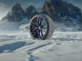 Winter-Komplettrad mit Alufelge im Schnee vor einer Bergkulisse
