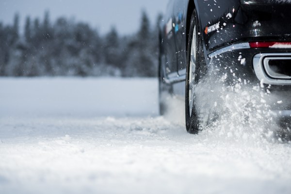 Auto fährt mit Winterreifen durch tiefen Schnee
